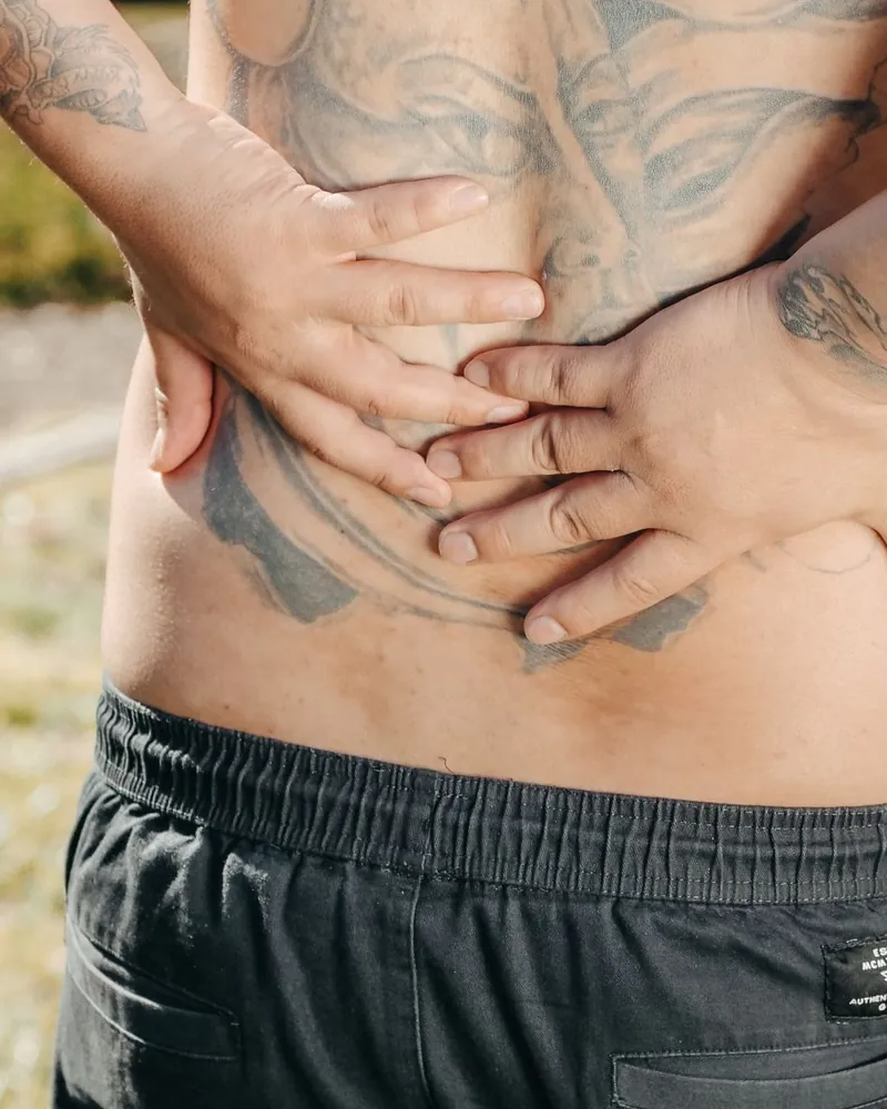 Homem com as mãos na lombar, com dor nas costas
