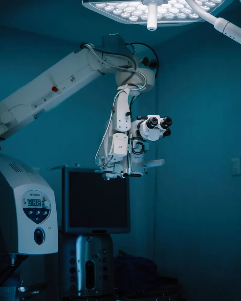 Sala cirúrgica com o braço articulado de um equipamento e o foco de luz no teto